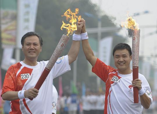 图文-奥运圣火在北京传递第2日 阮伟与李前光交接