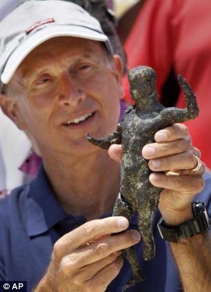 法国水下考古学家弗兰克·戈迪奥展示一个从伊希斯神庙新出土的铜像。