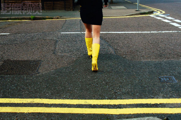 1. 明亮的黄色靴子和地上的两道黄线构成了一张醒目的图片。事实上，图片中的两只靴子也构成了两道黄线，而且是和路面相互垂直的两道线，图片的形式感很强。