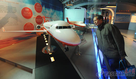 在“走近中国大飞机”展区，一位市民正在仔细观察ARJ21公务机模型