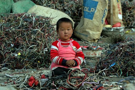 贵屿：小孩坐在电子垃圾周围