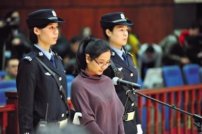 被告人卢梅低着头,站在朝阳法院刑事审判庭的被告席上。 被告人卢梅低着头,站在朝阳法院刑事审判庭的被告席上。
