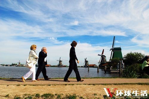 几位游客行走在风车村小河的堤坝上 几位游客行走在风车村小河的堤坝上