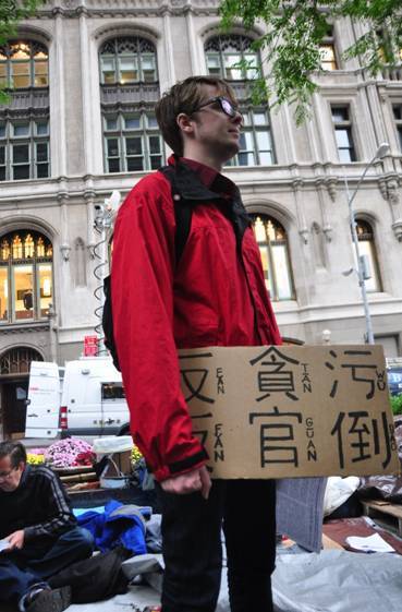 学生特里普举着用中文写的标语牌参加抗议。人民网记者李牧摄