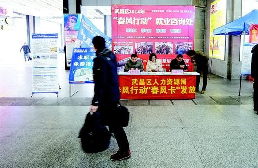 图为正月初九，武汉市武昌区劳动部门工作人员来到武昌火车站，将招工信息散发给刚下车的求职者。