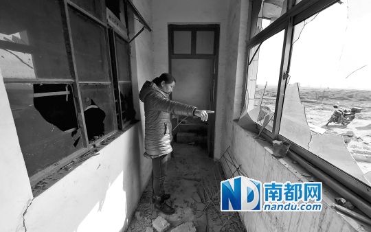刘寨村村民杨全德的女儿在家里被砸破的窗户前。新华社发