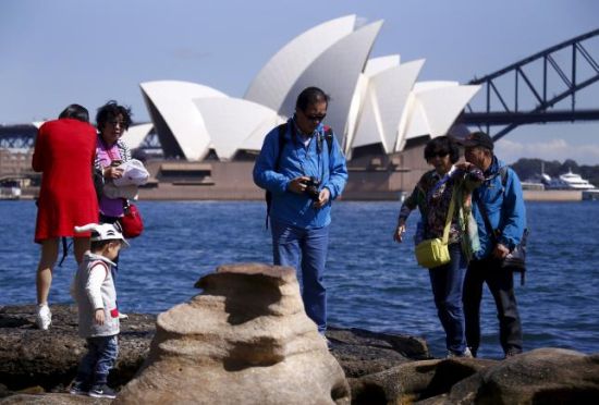  图为在悉尼歌剧院附近留影的中国游客。(Reuters)