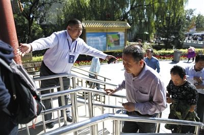 昨日，八大處公園保安隊長李建磊正在門口疏導遊客。新京報記者 浦峰 攝