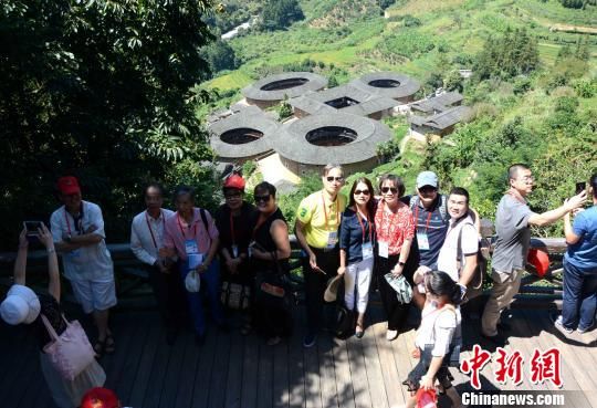 图为海外华文媒体代表与土楼群合影。 张金川 摄 图为海外华文媒体代表与土楼群合影。 张金川 摄