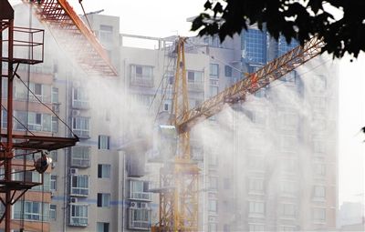 為降低工地揚塵，鄭州部分工地塔吊鋪設“淋浴”系統，噴水霧降塵。 圖/CFP