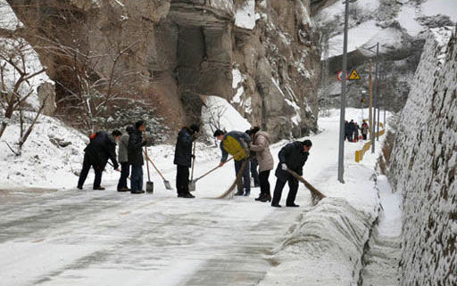 景区工作人员清扫路上积雪 华山景区工作人员清扫积雪确保游客通行(图)
