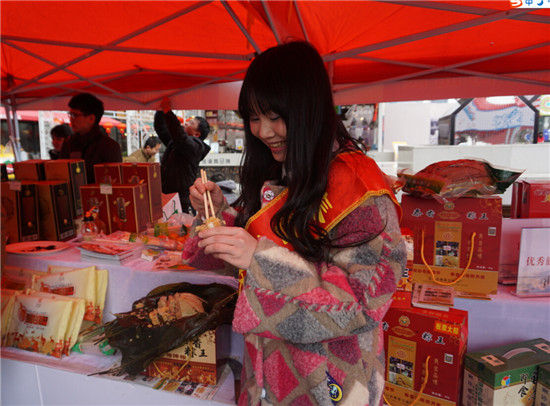 活动现场展示钦州旅游特产,市民品尝钦州香粽王(图:韦兰思) 春节旅游好去处——钦州