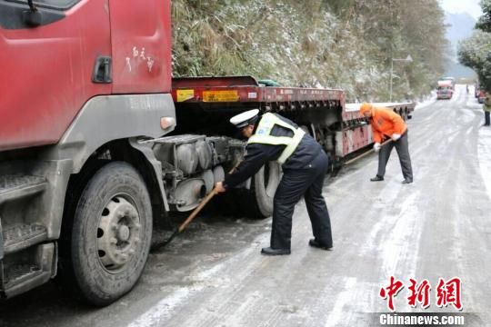 S317线9Km处南丹段路面结冰湿滑,货车发生侧滑后又被冰阻路,民警帮助铲雪除冰后指挥车辆重新起步(图:黄海镜) 钦州60岁老人上山赏雪被困 交警及时救援