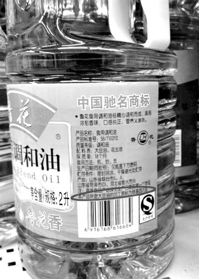 昨日，宣武门一超市内的两款调和油，均用小字标注转基因字样（圆圈内）。新京报记者 邓琦 摄