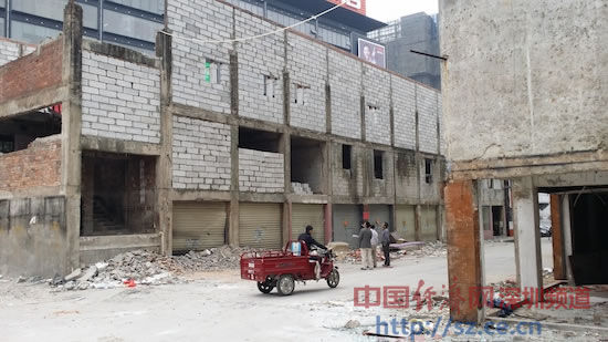 图为位于深圳龙华民治万众城家居广场和骏景华庭小区之间的烂尾楼正在加建。中国经济网深圳频道摄