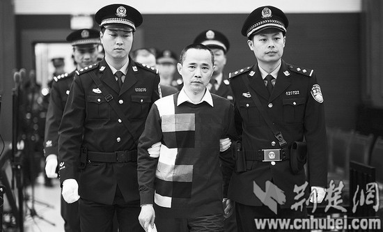 图为：刘维(前中)等7名被告人被法警带到法庭受审。(报道组 摄)