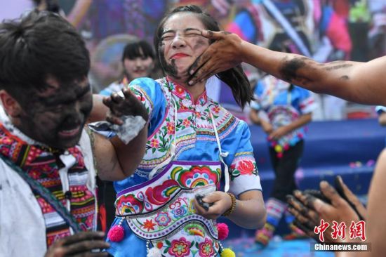 民众相互抹脸庆祝“花脸节” 云南丘北举办“花脸节” 千人相互抹脸送祝福