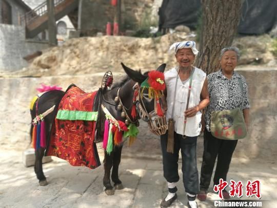 山西吕梁修建320公里沿黄扶贫公路,修好后,游客可畅享黄河美景。图为碛口古镇里的老农民夫妇,他们以向游客提供骑驴拍照为生。 李娜 摄 山西投50亿建吕梁旅游公路扶贫 320公里赏黄河美景