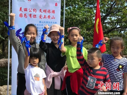 游客手举蓝丝带 侯晏 摄 安徽黄山风景区国庆期间倡导游客环保出行