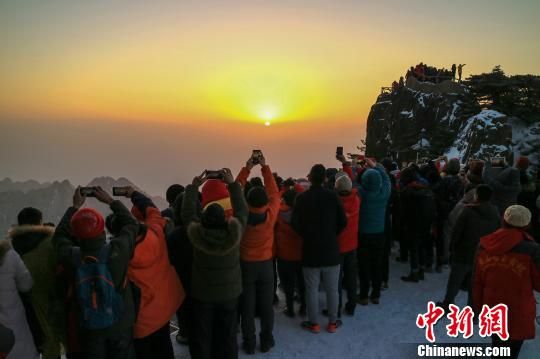 11日早晨,游客在黄山光明顶拍日出。 李金刚 摄 安徽黄山雪后放晴 日出、怪石、奇松竞秀
