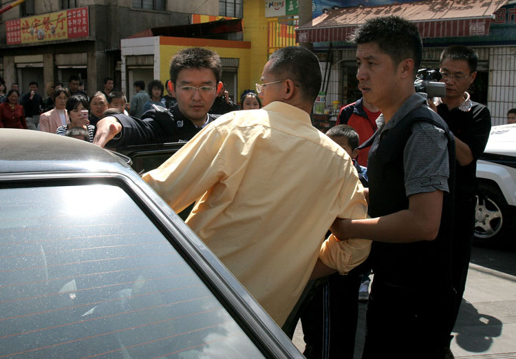 图文:绑架人质的男子被警方押进警车