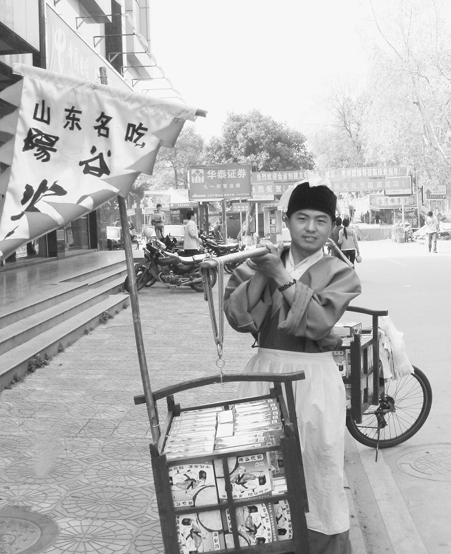 一男子武大郎打扮 街头高声叫卖炊饼