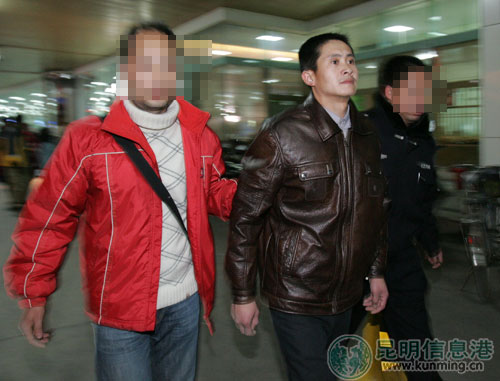 徐应江(中)被民警押回昆明.记者杨海冬/摄