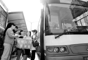 昆明市金星社区党员在公交站台劝导市民文明乘车