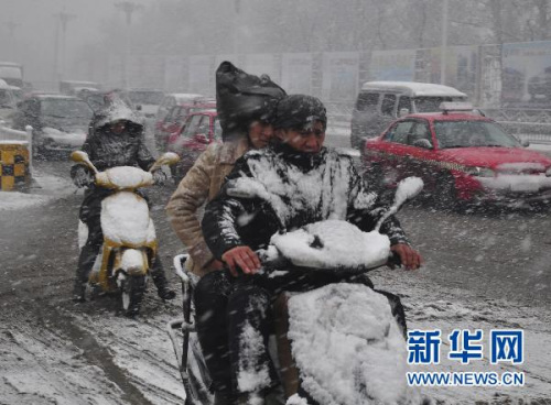 11月13日，黑龙江牡丹江市民冒着风雪在街头骑行。新华社发(张春祥 摄) 