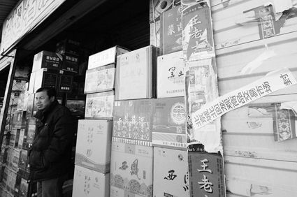 今天上午，在城北回龙观交易市场，一家出售昌黎产地红酒的店铺被封 摄/记者林晖
