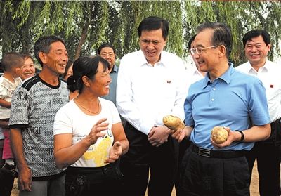 8月26日，温家宝在万全县向挖土豆的农民询问土豆产量、价格和销路。 新华社发