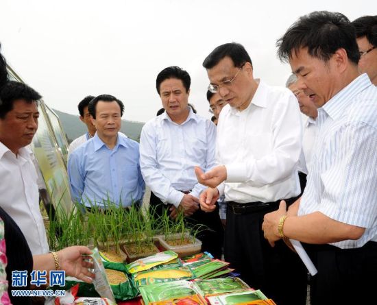 3月30日至4月2日，在出席博鳌亚洲论坛2012年年会期间，中共中央政治局常委、国务院副总理李克强来到海口、澄迈、琼海等地进行考察调研。这是3月31日，李克强来到琼海市博鳌镇的北山洋，与田间作业的农民和育种专家亲切交谈。 新华社记者 饶爱民 摄 