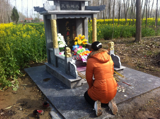 吴晓雅跪在丈夫的墓前哭诉，墓碑是以他们儿子的名义立的。 中国青年网通讯员 王奕摄
