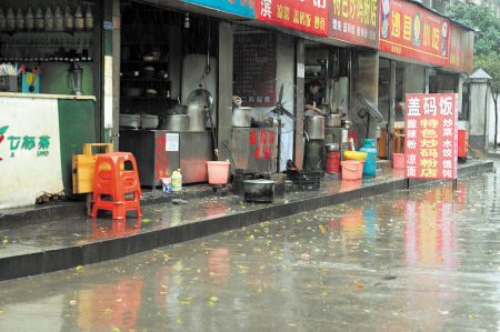 油污遍地 湘湖路边的这几家早餐店把厨具摆到了马路上，油污满地。