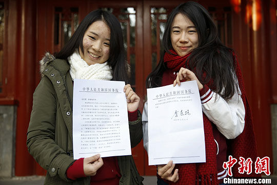 12月17日，泰国华裔留学生李慧敏（左）与白云莹手持中国国务院总理李克强的回信在校园内合影。中新社 王骏 摄  