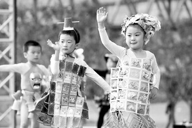 幼儿园小朋友穿着各种废弃材料制成的衣服表演