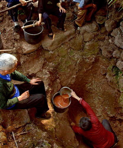 图文：村民们在泥井里轮流守候取舀泥浆水