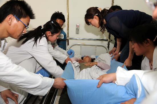 图文:淄博中医院医务人员在照顾一名受伤乘客