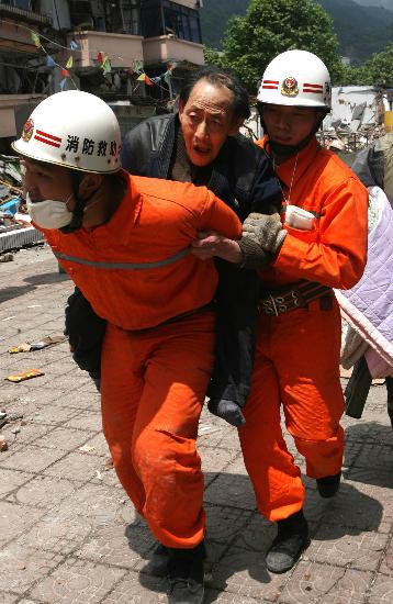 图文:消防队员将71岁老人从德阳危险楼房中背