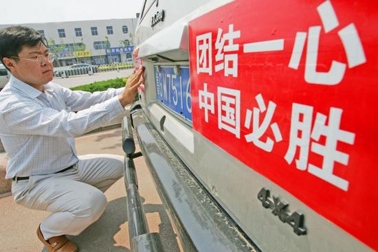 组图:男子将中国必胜标语张贴在车上
