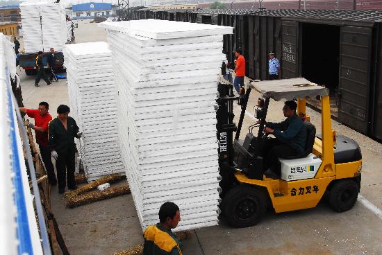 图文:装卸工人搬运发往灾区的活动板房材料