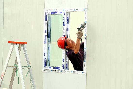 图文:中建八局工人正在安装过渡安置房门窗