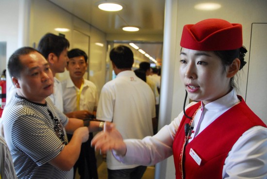 甬台温铁路温州火车站,乘务员在引导旅客上车.