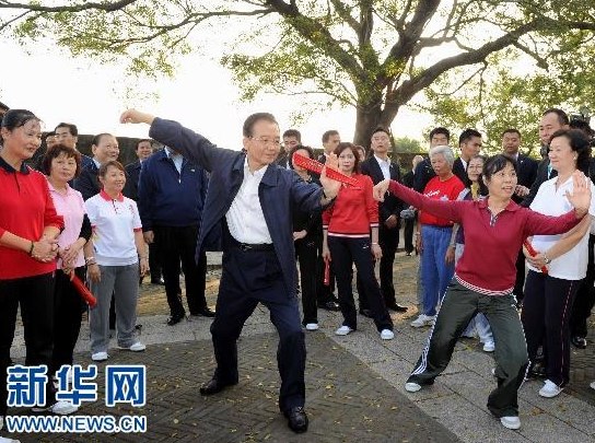 11月14日，国务院总理温家宝来到澳门大炮台花园，同在这里晨练的市民亲切交流，一起练习太极拳并学练太极扇。 新华社记者 饶爱民 摄 