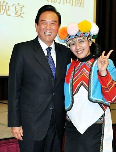 陈云林（左）25日晚上在嘉义市耐斯王子饭店出席欢迎晚宴，并与现场表演传统舞蹈的邹族少女合影留念。“中央社”图
