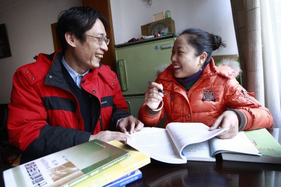 席朱雪芹(右)与丈夫一起在家中自学工商管理本