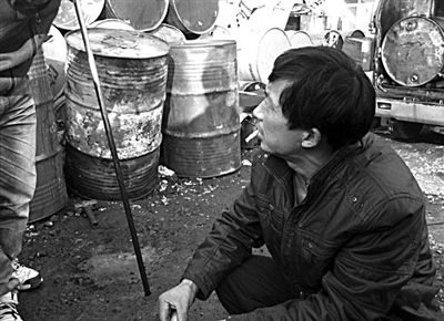 收废机油的小贩向暗访记者展示，用一根小钢管插入油桶，检查油质是否含水，这是小贩们常用的辨油方法。