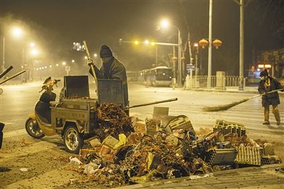 大年初一凌晨，龙潭湖公园西北门，环卫工人在清扫烟花屑。 新京报记者 周岗峰 摄