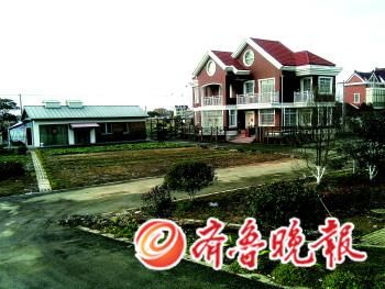 陆家“豪宅”目前已将围墙栅栏拆除,但房屋前的承包地,仍是由大片硬化路面和花草构成的“花园”。 陆家“豪宅”目前已将围墙栅栏拆除,但房屋前的承包地,仍是由大片硬化路面和花草构成的“花园”。