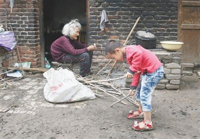 河南省鲁山县大潘庄，一位81岁的老太和孙子在一起，她的子女都已出外打工。据统计，鲁山县将近半数的农村老人是空巢老人。新京报记者 尹亚飞 摄